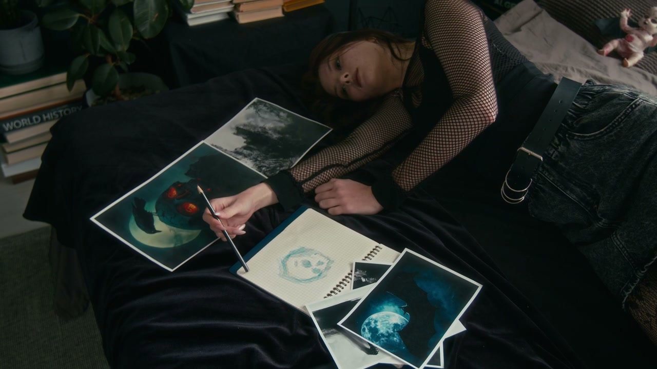 Gothic Girl Sketching Artwork on Bed