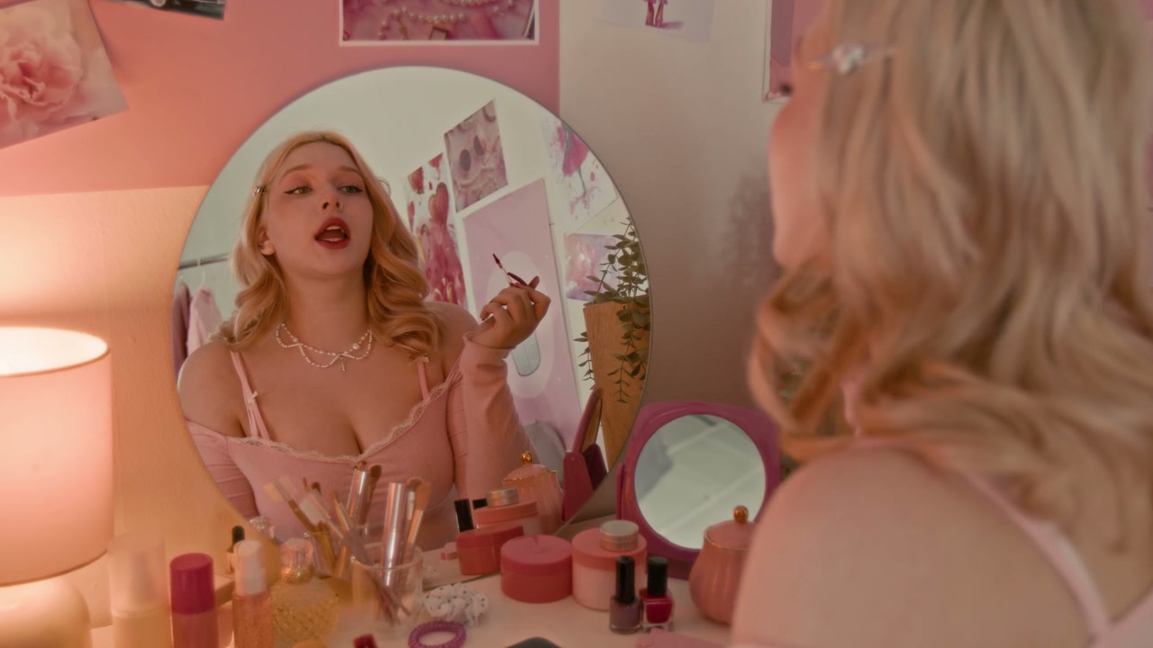 Blonde Woman Applying Lipstick at Pink Vanity