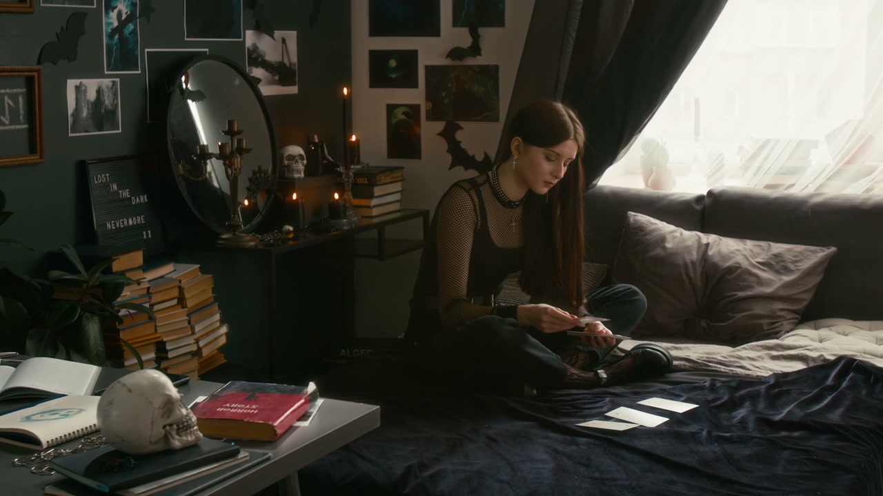 Young Person Arranging Tarot Cards in Goth Room