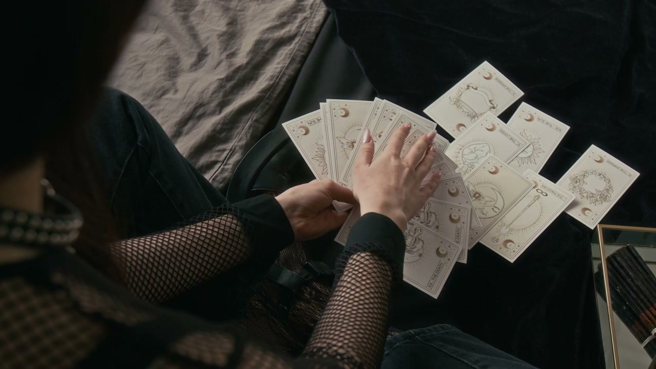 Gothic Person Handling Tarot Cards on Bed