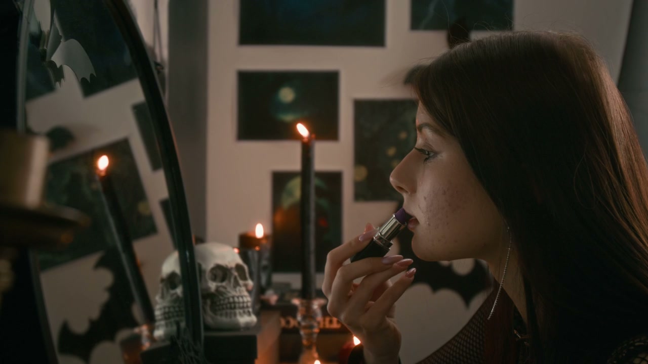 Gothic Teenager Applying Lipstick in Dark Room