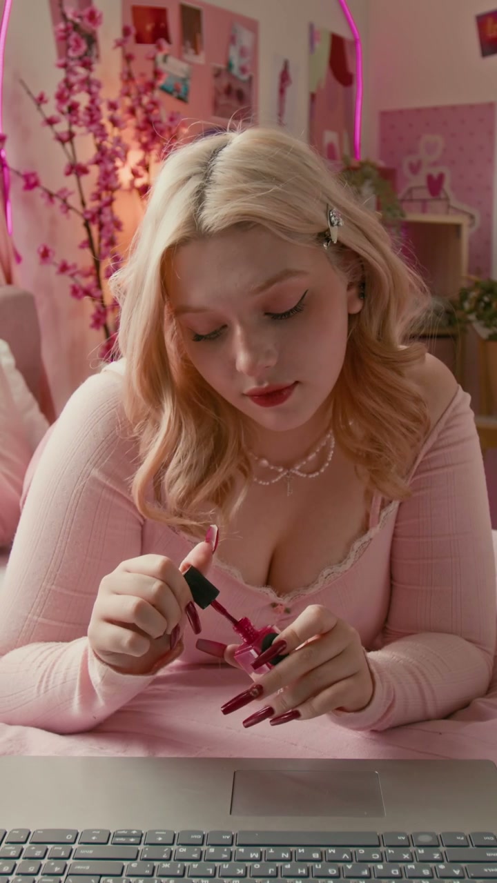 Blonde Girl Painting Nails in Pink Bedroom