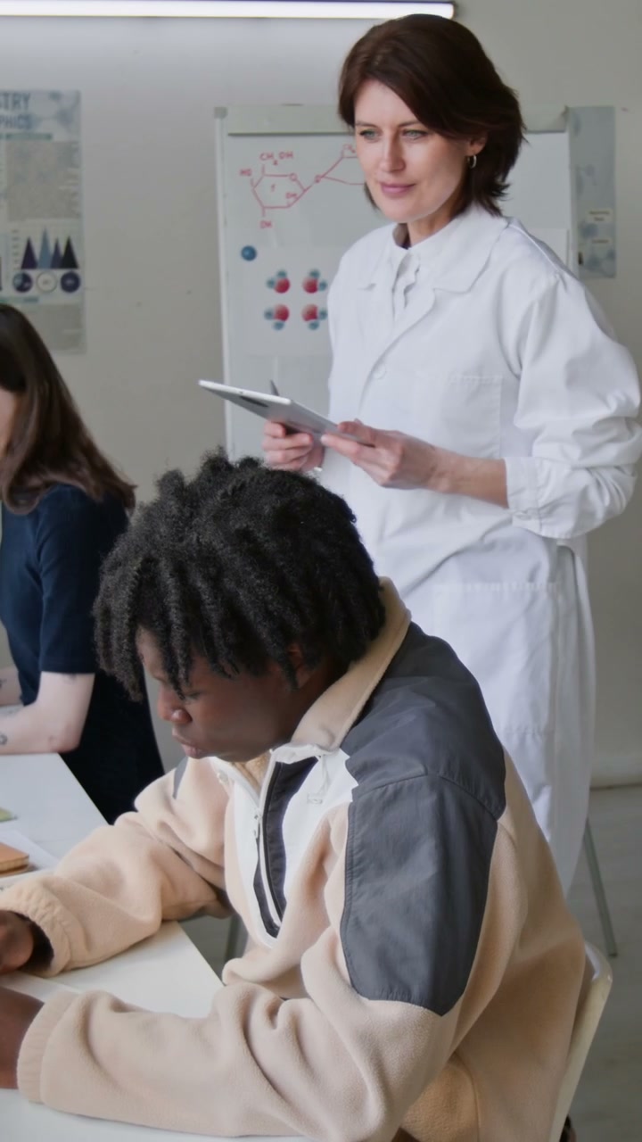 Teacher Assisting Students in Science Class