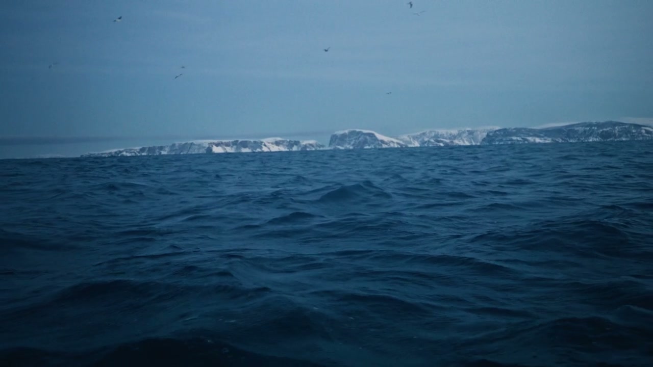 Rough Arctic Ocean with Distant Snowy Mountains