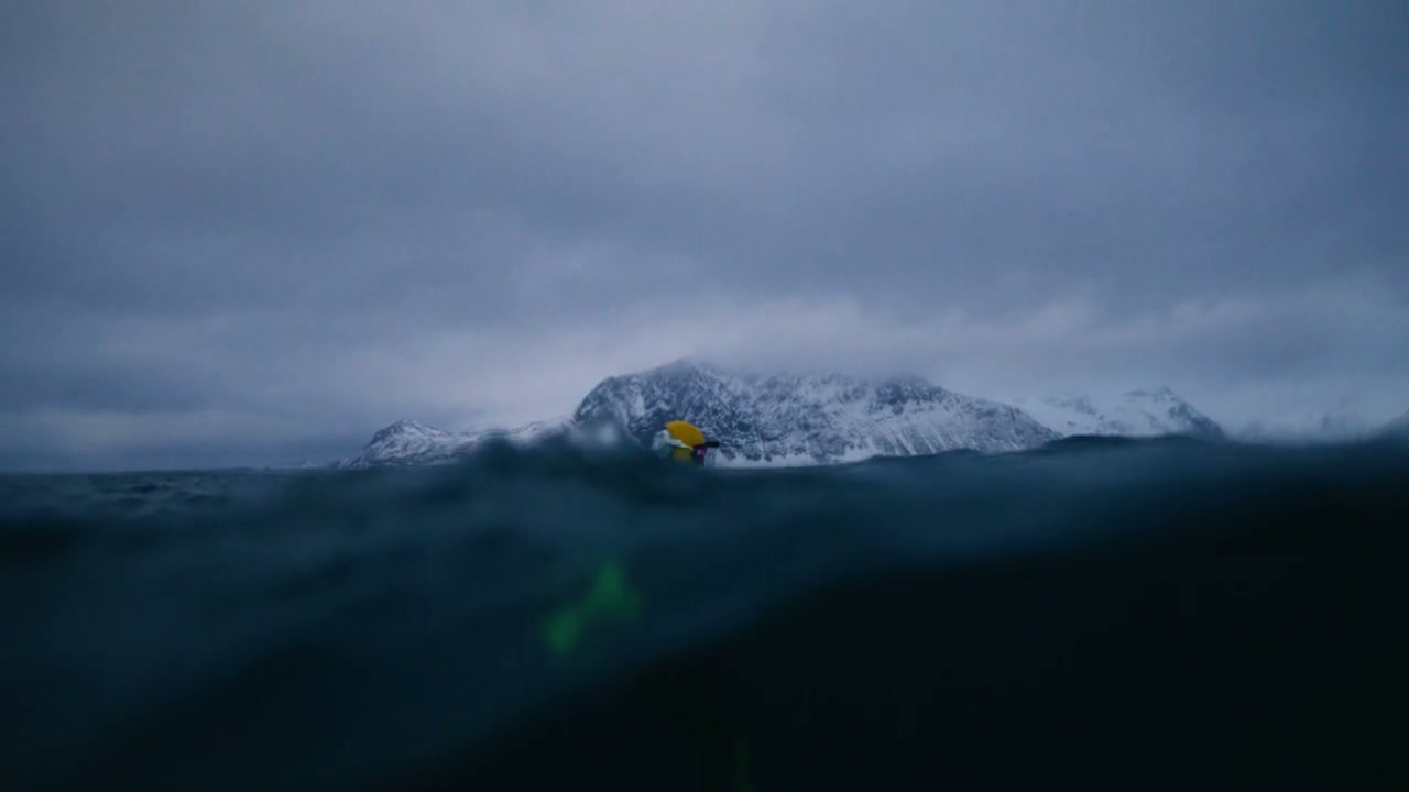 Snorkeler in Cold Ocean with Snowy Mountains