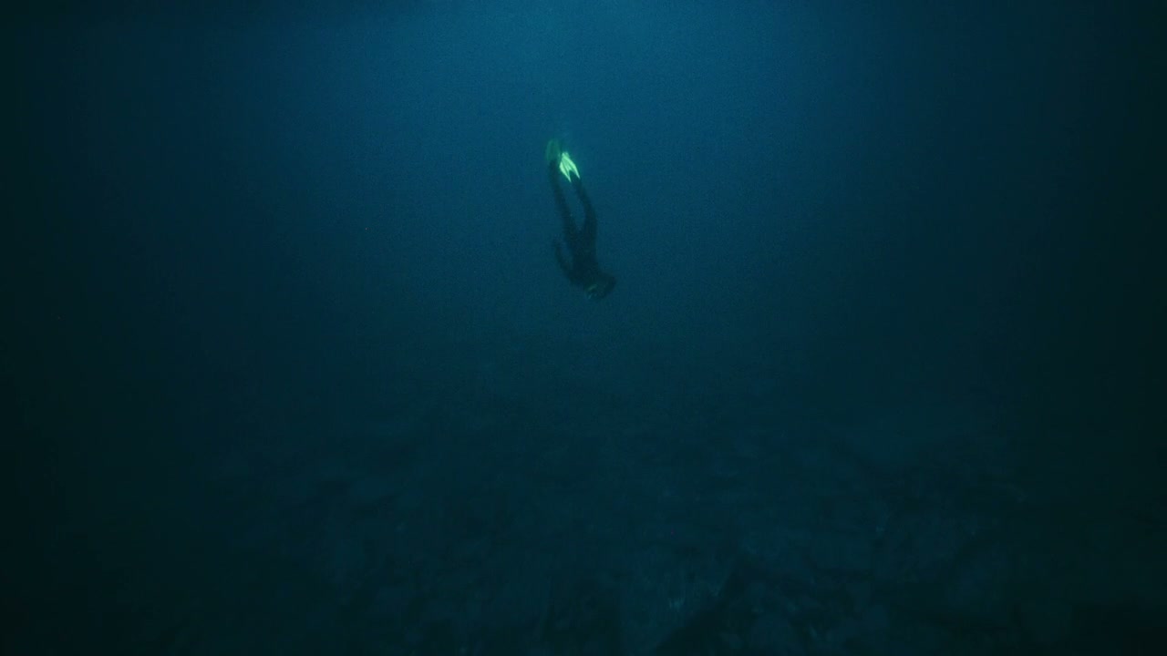 Freediver Descending into Dark Arctic Water