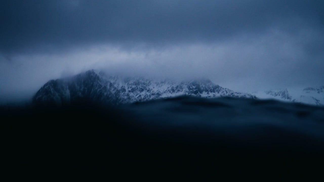 Dramatic Ocean Waves and Snowy Mountains