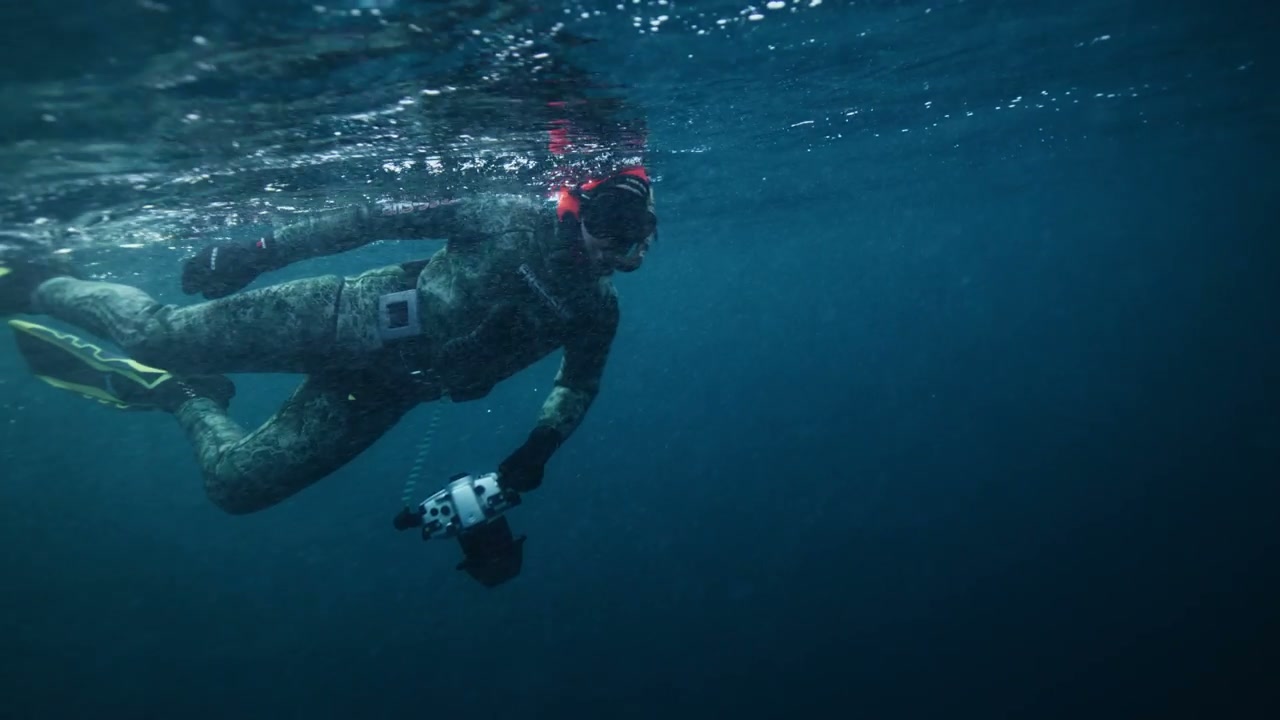 Diver With Camera Swimming Underwater