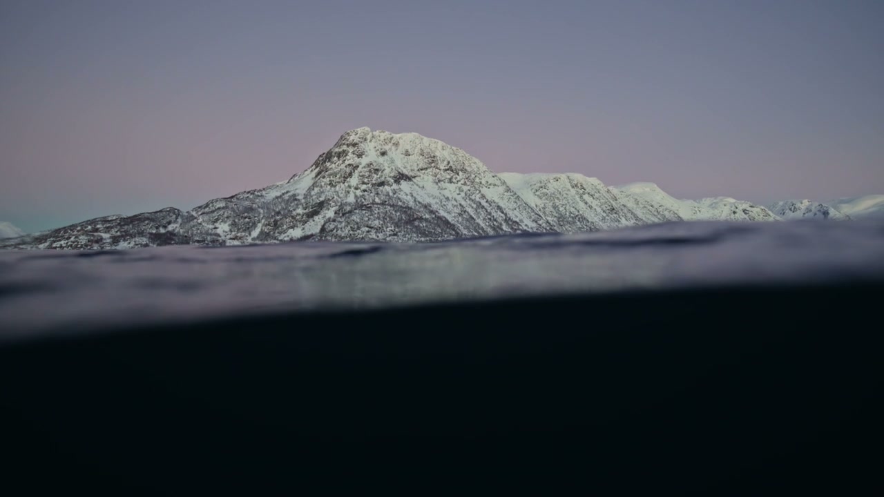 Half Submerged View of Snowy Arctic Mountains