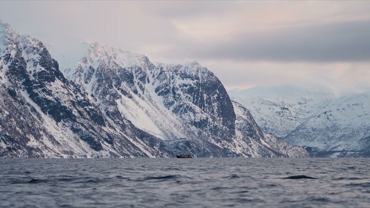 Boat in Fjord Amidst Snow-Covered Mountains