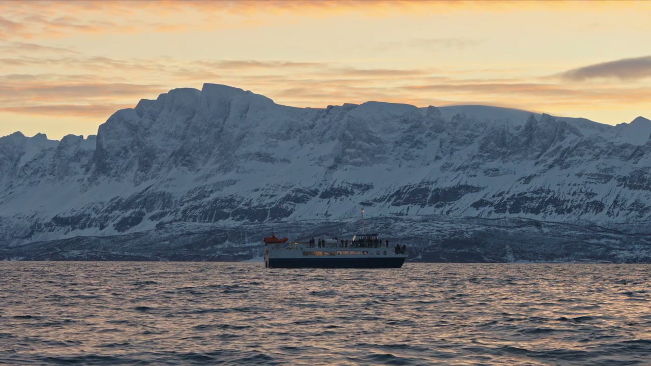 Arctic Cruise Boat at Sunset with Snowy Mountains