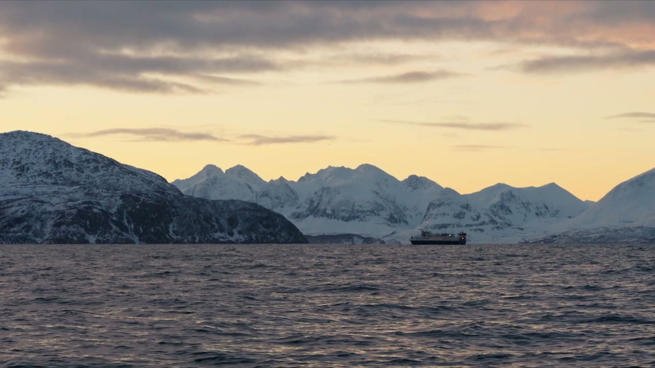 Ship Sailing Through Arctic Fjord at Sunset
