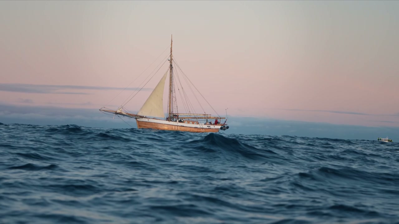 Sailboat Sailing on Wavy Arctic Sea at Dusk