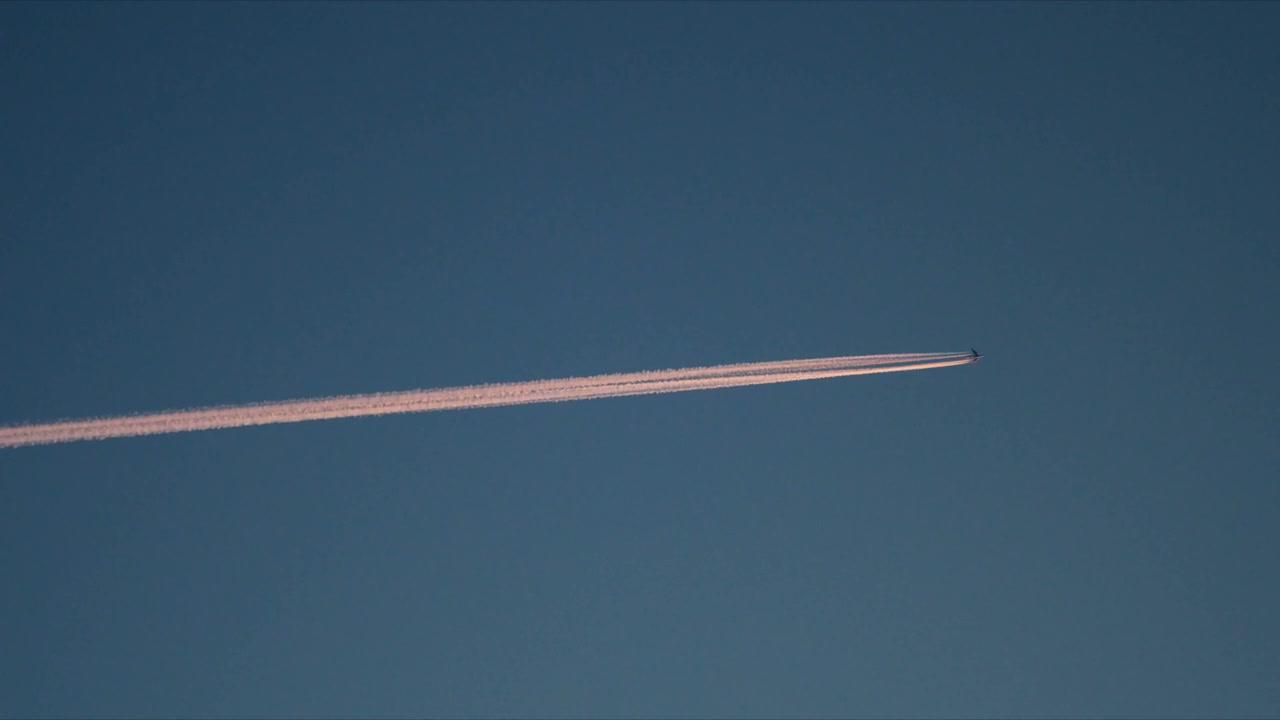 Airplane Flying with Contrail in Blue Sky