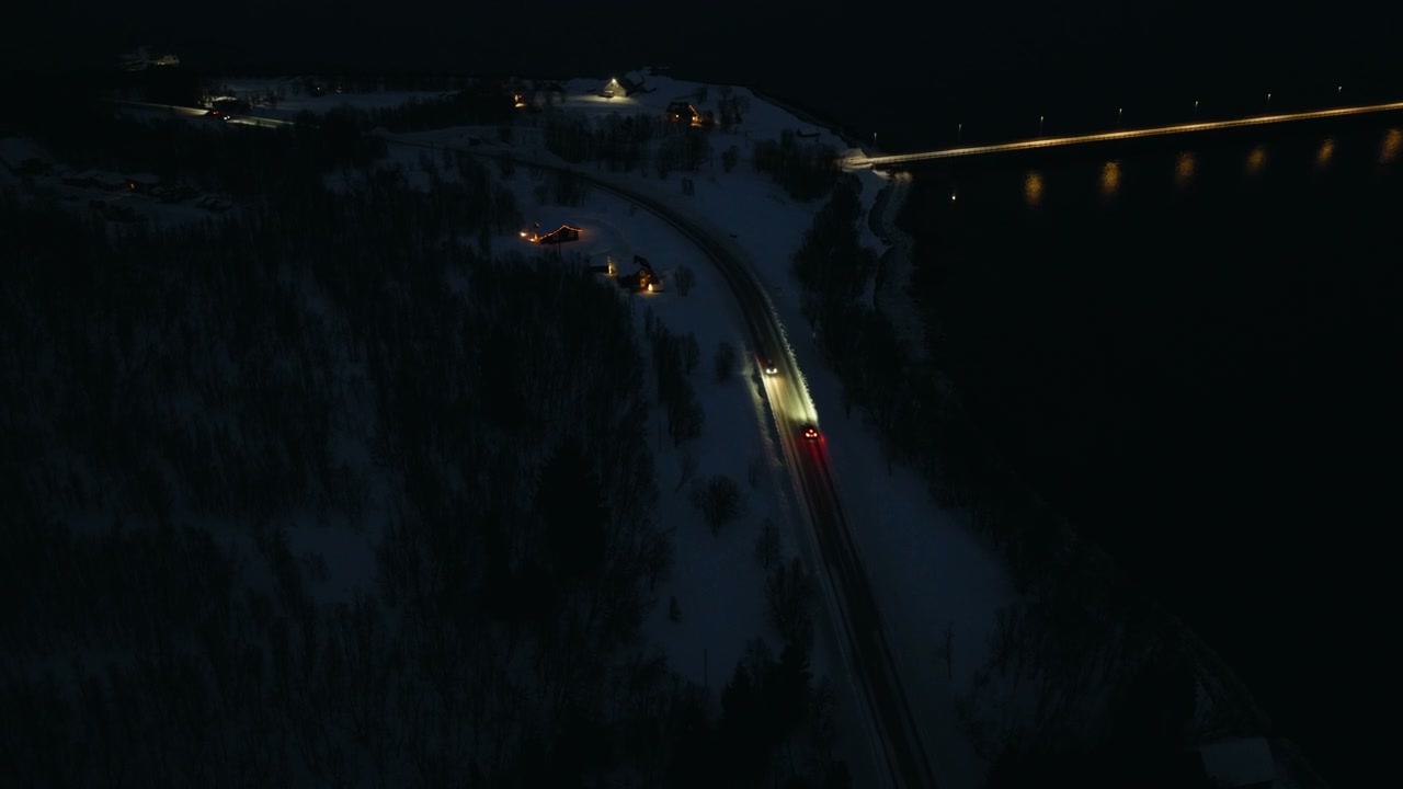 Aerial View of Cars on Snowy Arctic Road at Night