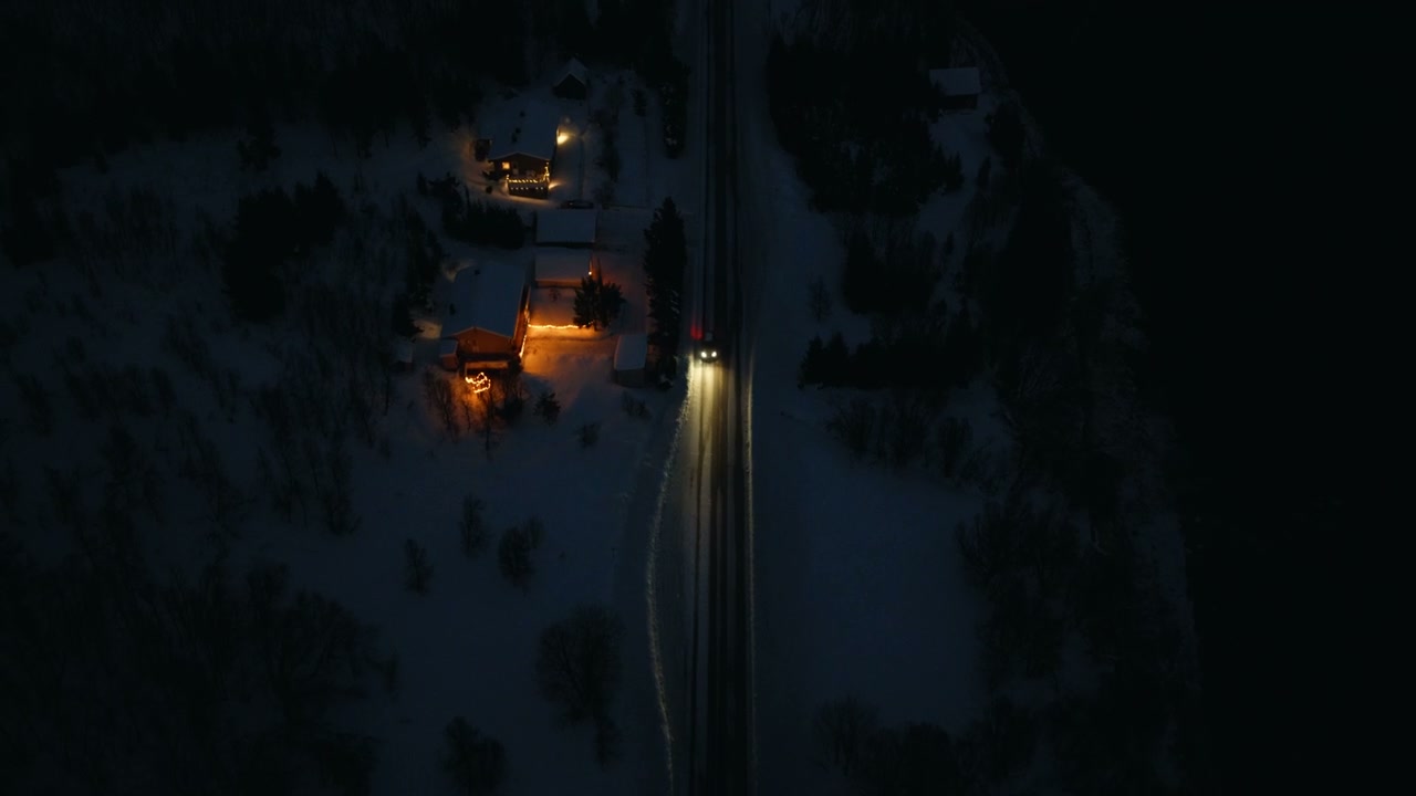Car Driving on Snowy Arctic Road at Night