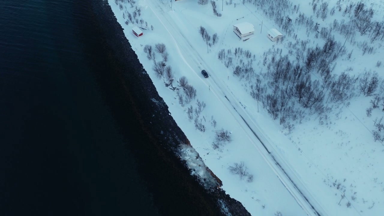 Car Driving on Snowy Road Along Arctic Fjord