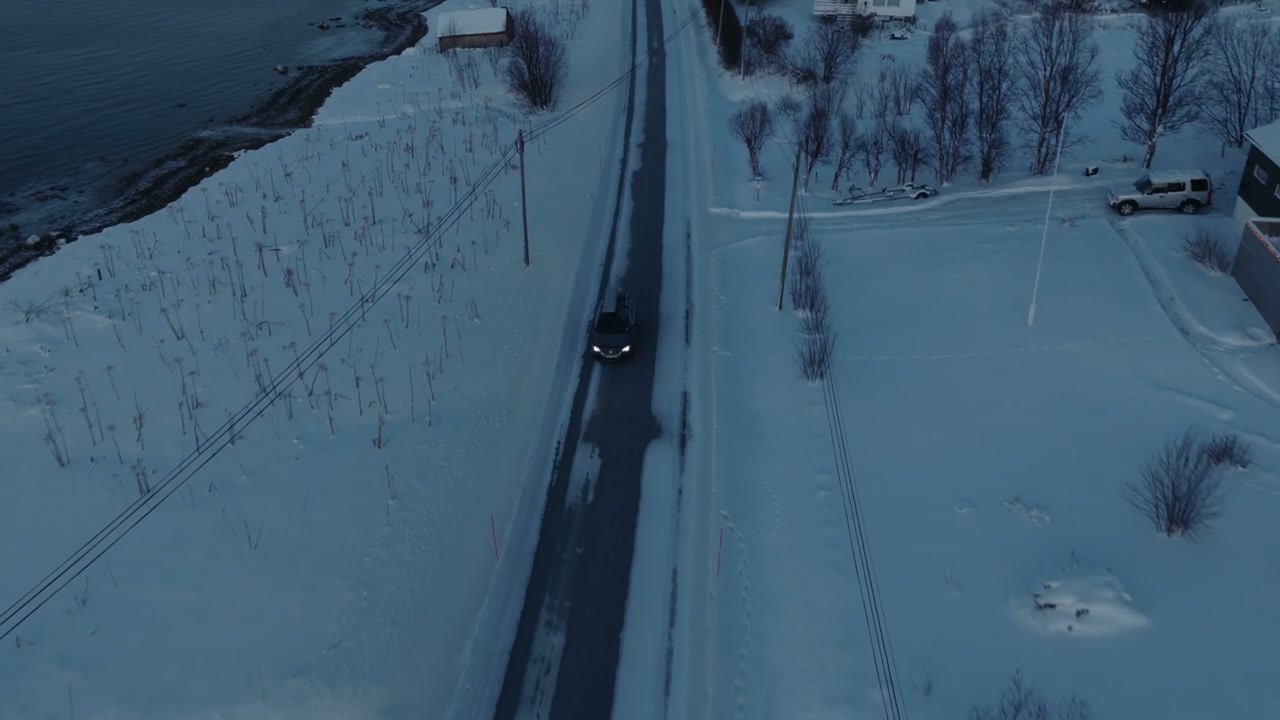 Car Driving on Snowy Coastal Road in Arctic