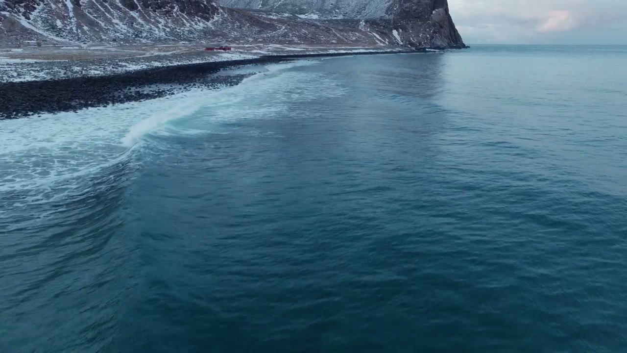 Snowy Mountain Coastline with Surfer and Waves