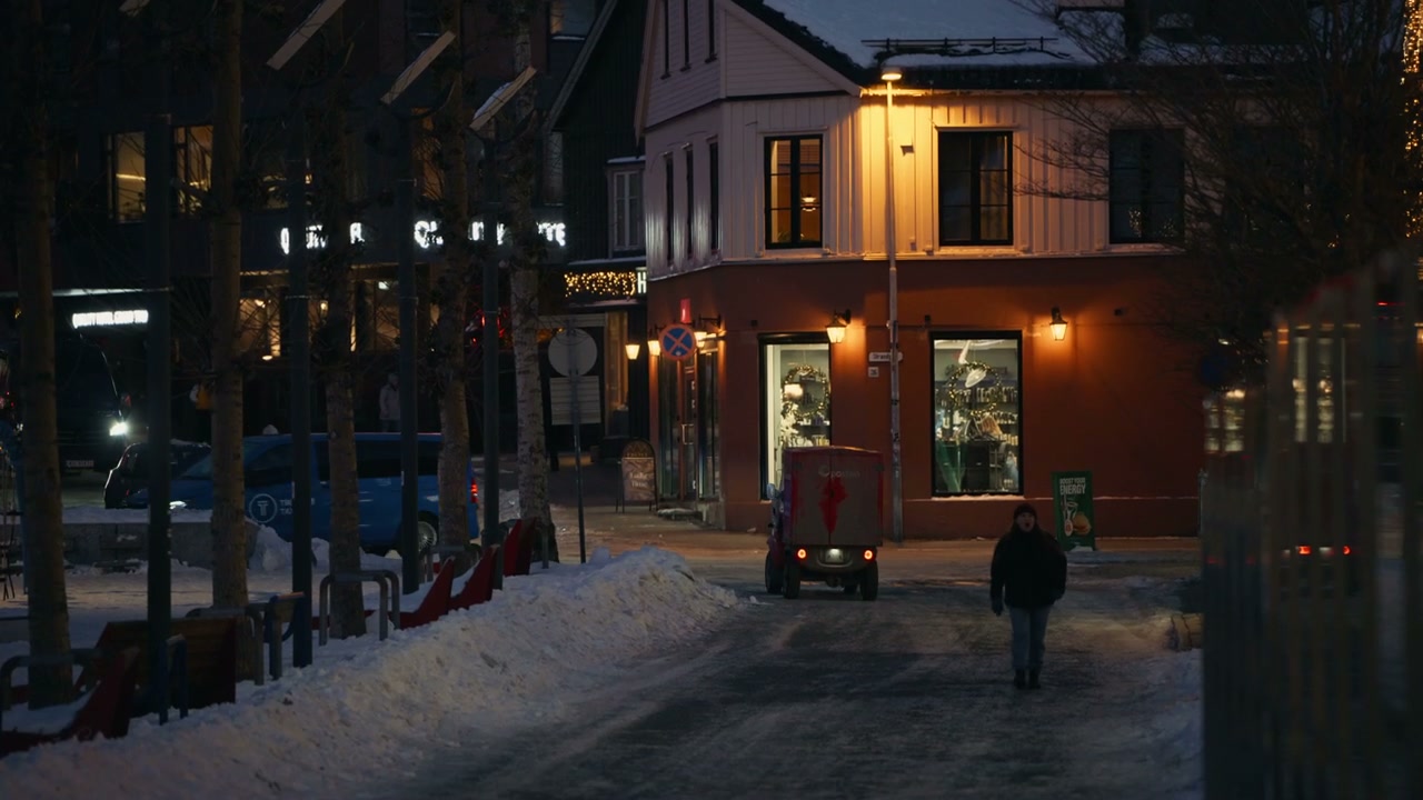 People Walking on Snowy Town Street at Night