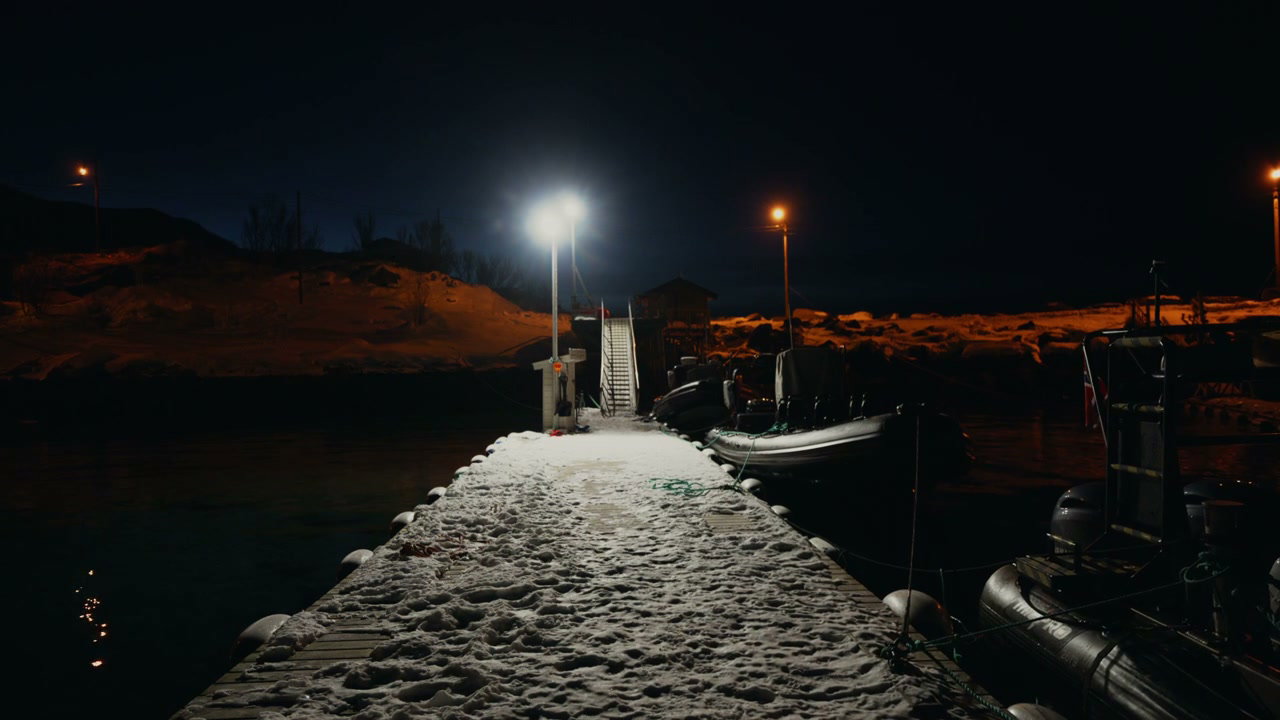 Snowy Pier and Boats at Night in Arctic Harbor