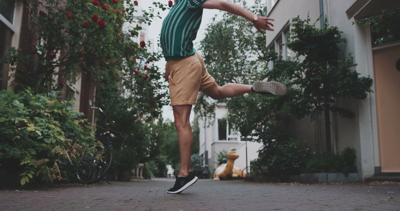 Person Playfully Jumping in Urban Alley