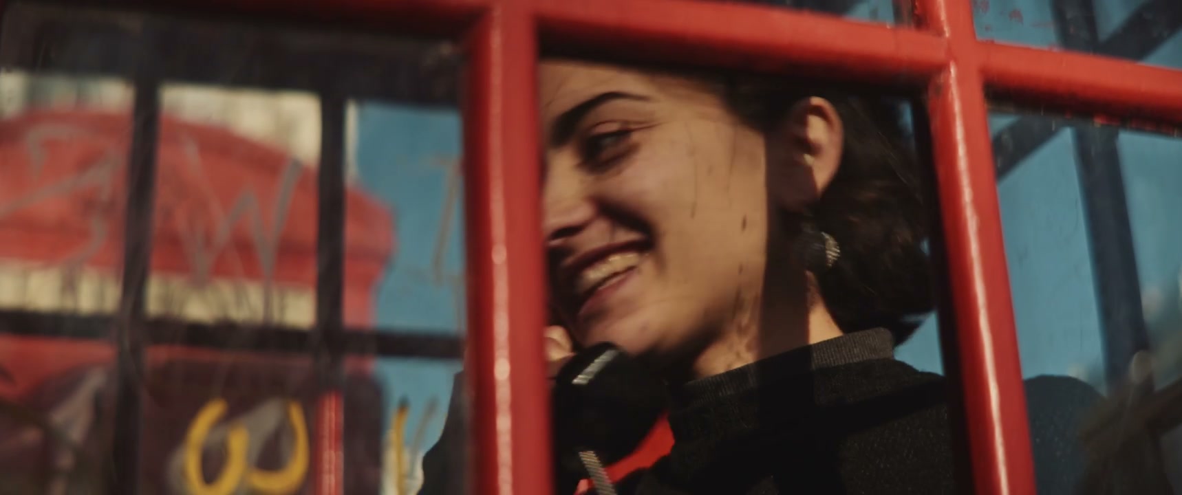 Smiling Woman Talking in Red Phone Booth