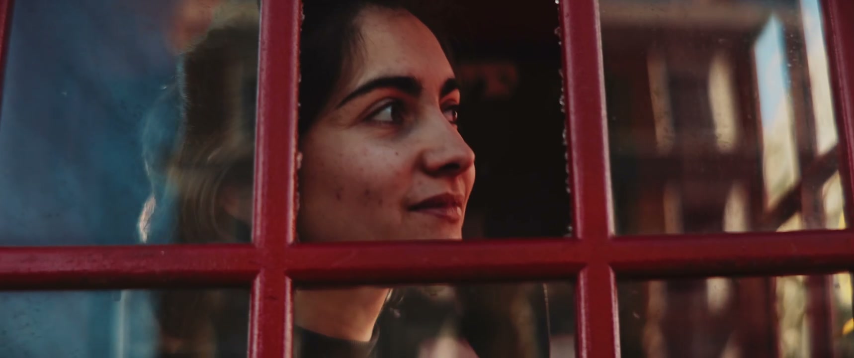 Woman Talking in Red Telephone Booth