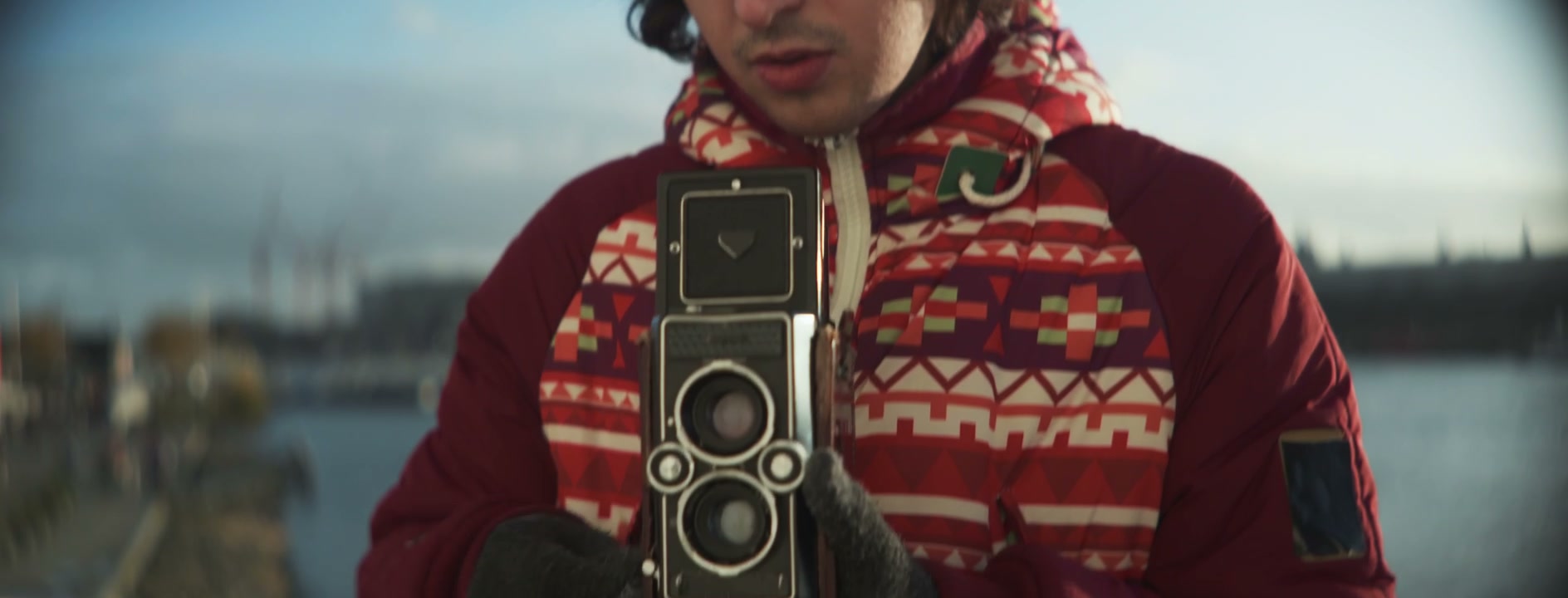 Person in Winter Coat Holding Vintage Camera