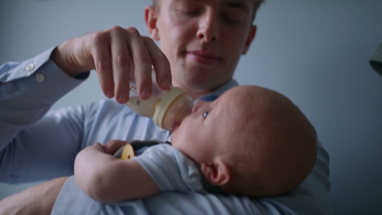 Man Bottle Feeding Baby