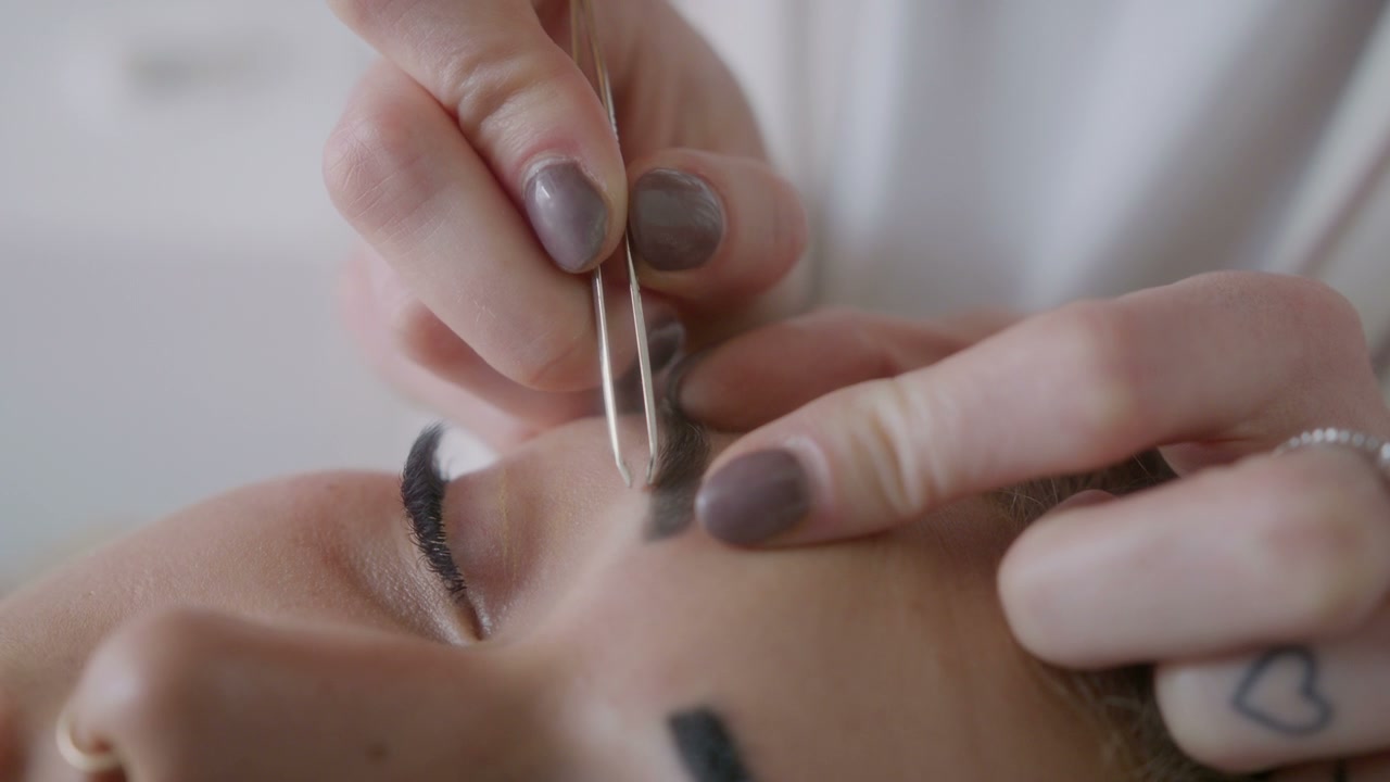 Beautician Plucking Eyebrows