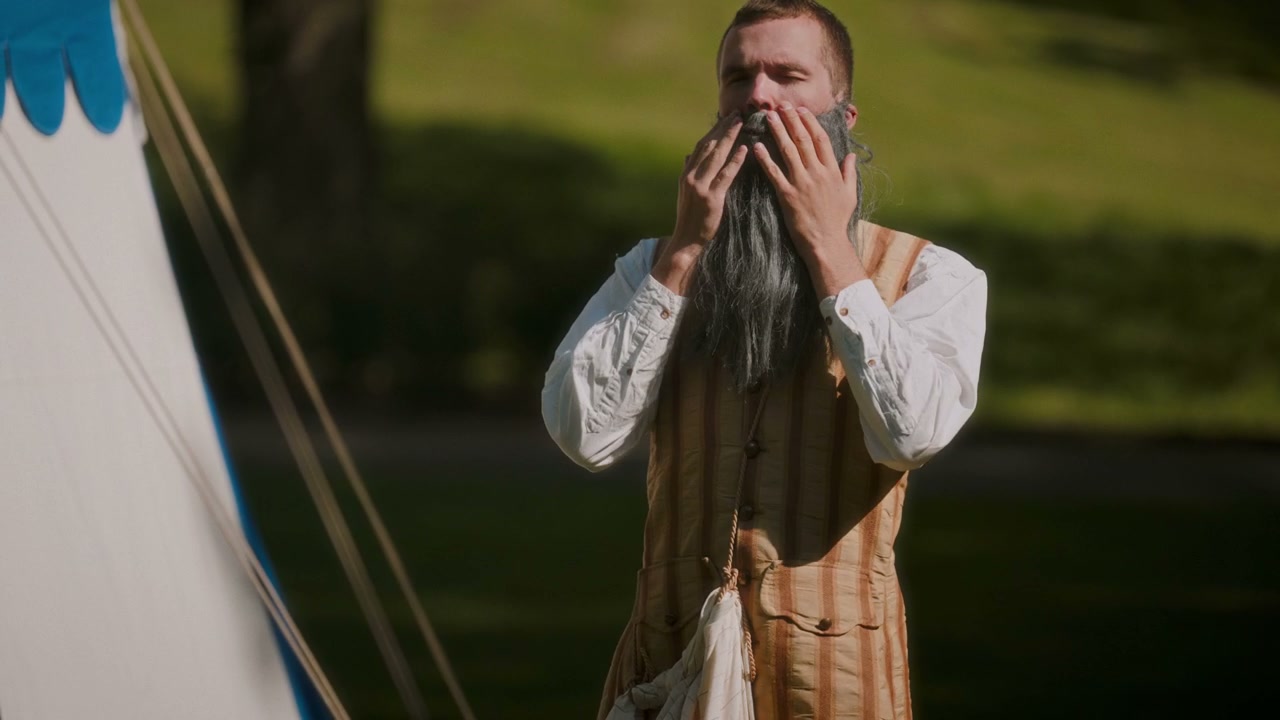 Actor Adjusting Fake Beard in Costume Outdoors