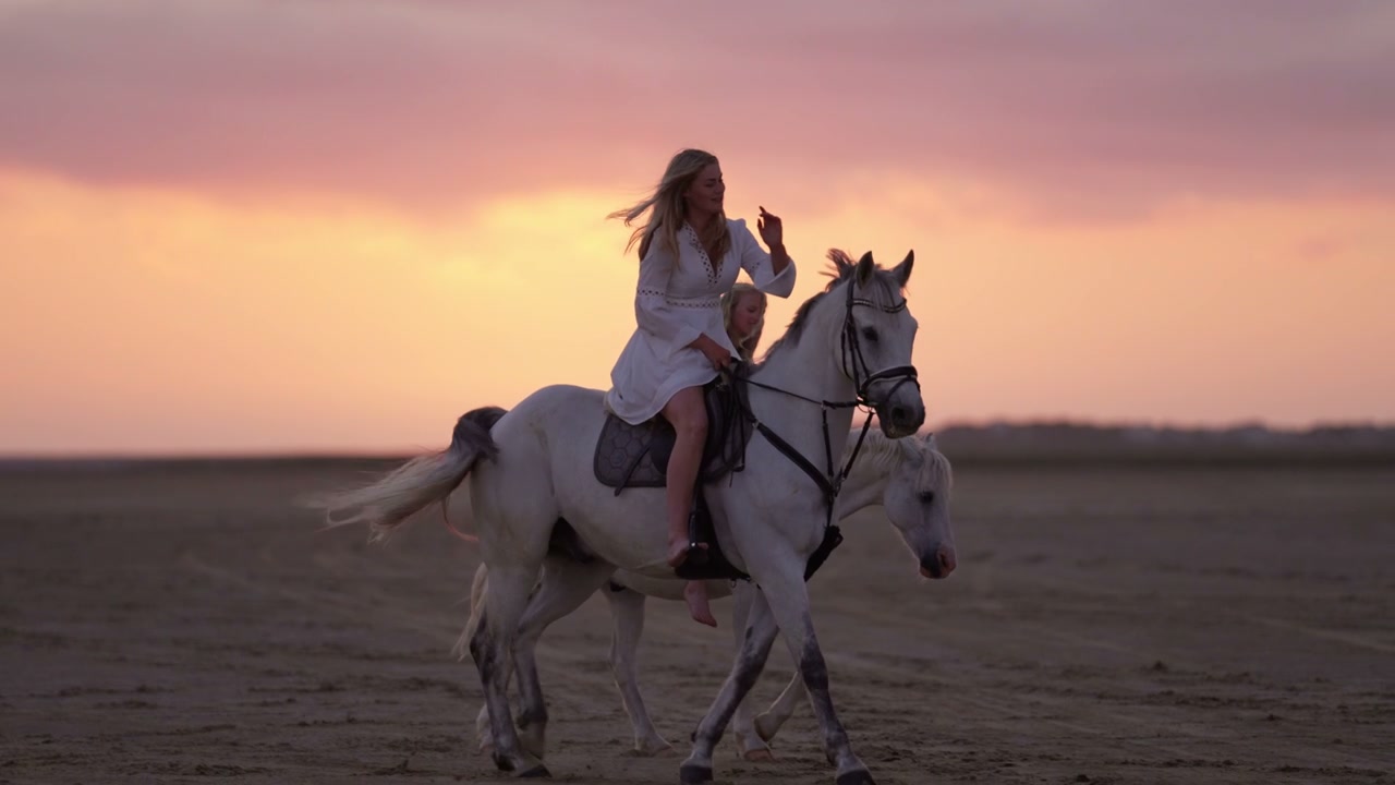 Woman and Girl Horseback Riding at Sunset
