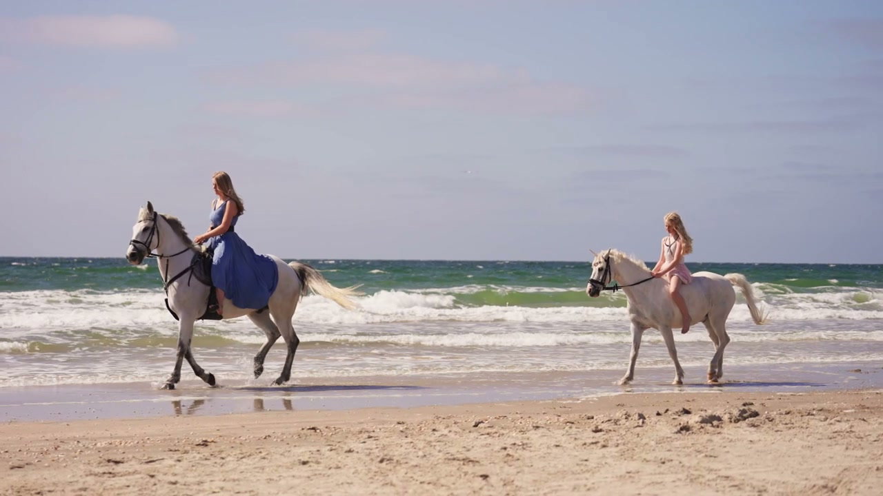 Two Women Riding Horses on a Sandy Beach • Stock Video on Uppbeat