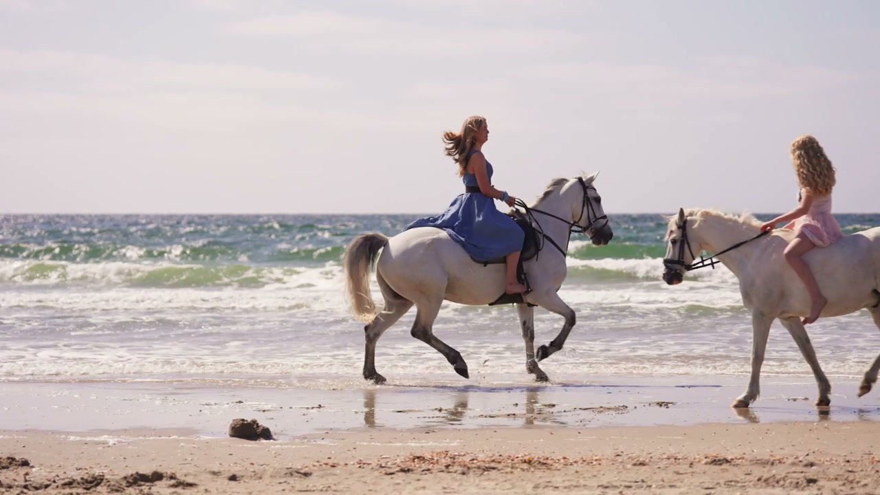Two Women Riding Horses on a Sandy Beach • Stock Video on Uppbeat