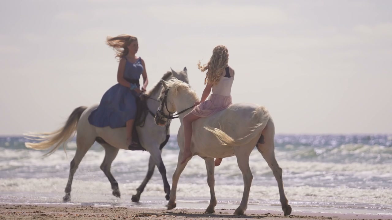 Two Women Riding Horses on a Sandy Beach • Stock Video on Uppbeat