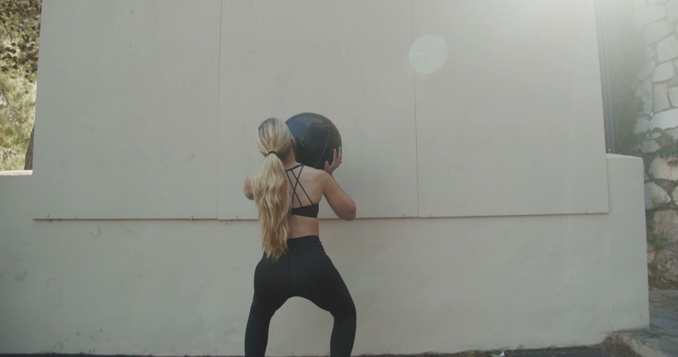 Woman Doing Wall Ball Exercises Outdoors