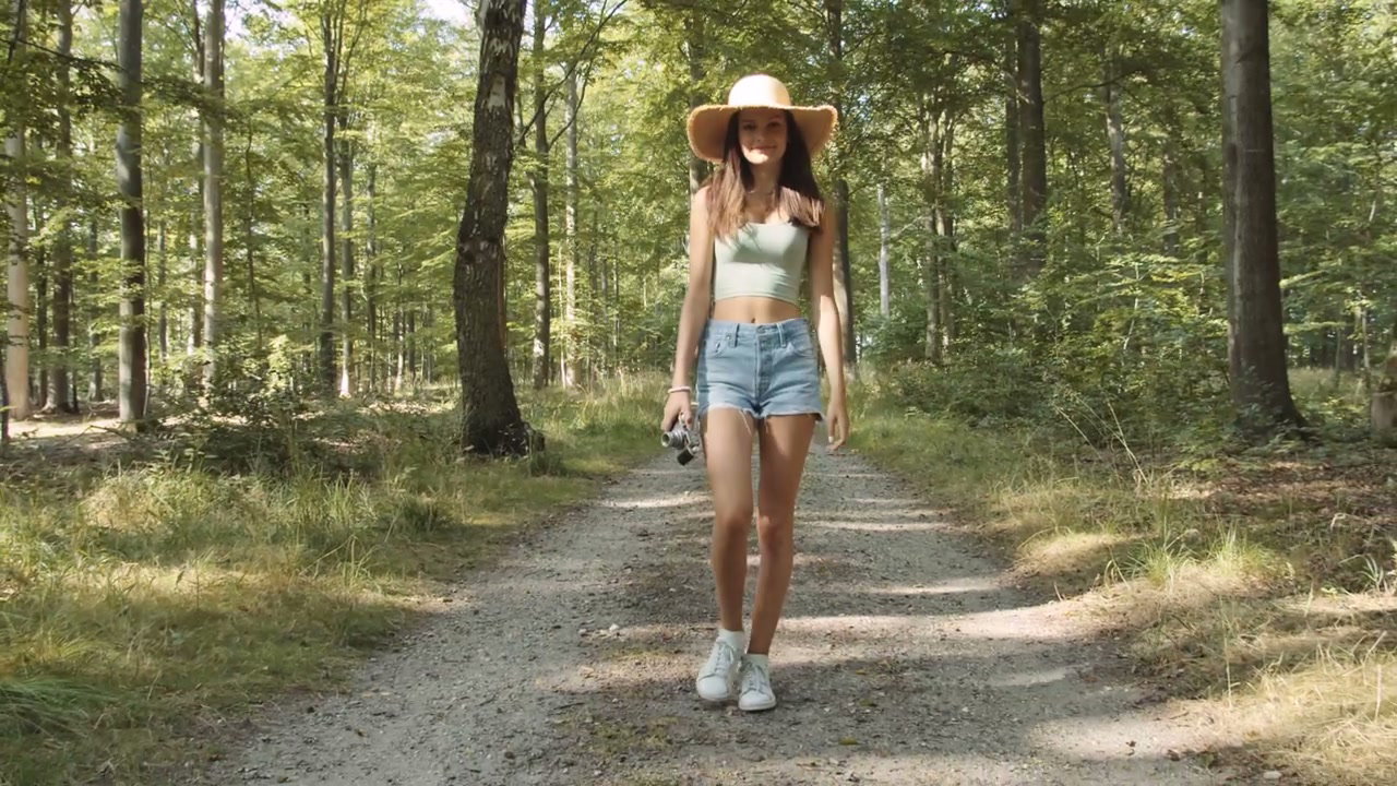 Woman Walking Forest Path With Vintage Camera
