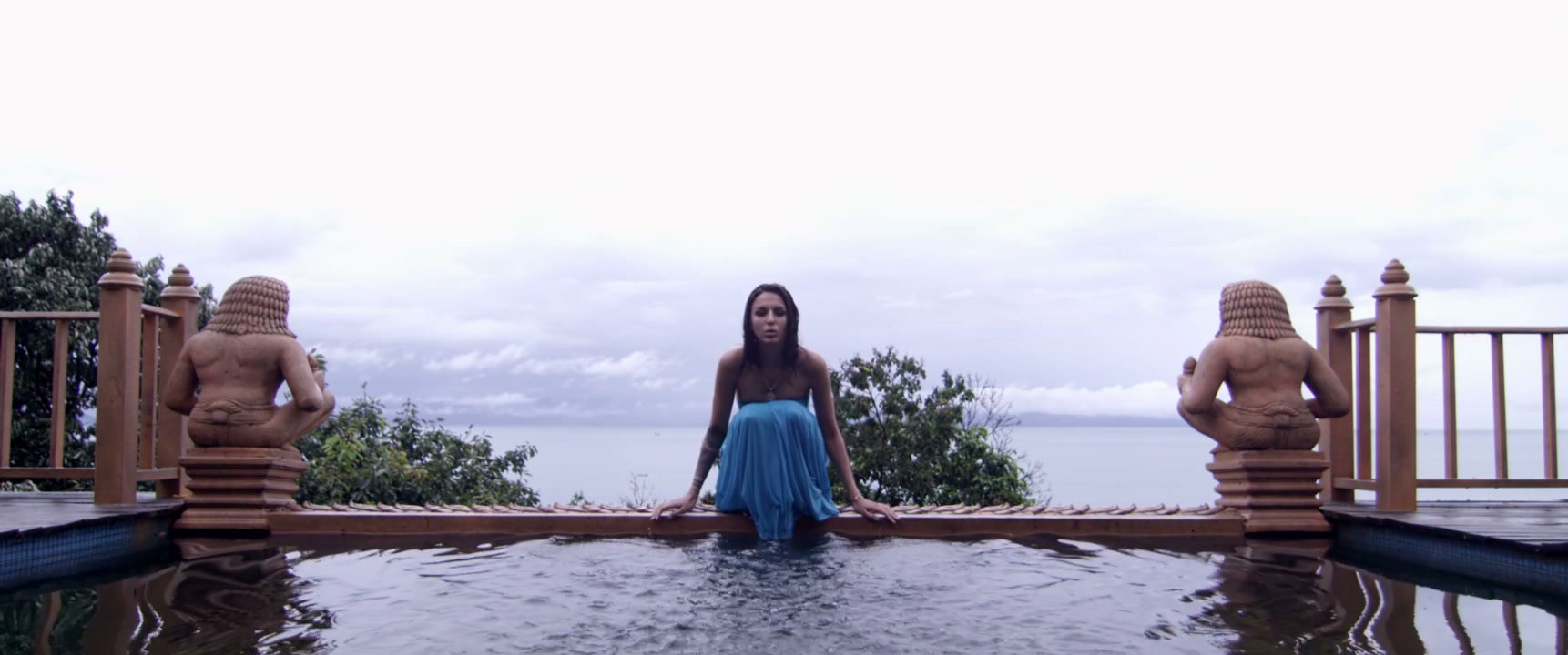 Woman Splashing Water in Exotic Infinity Pool
