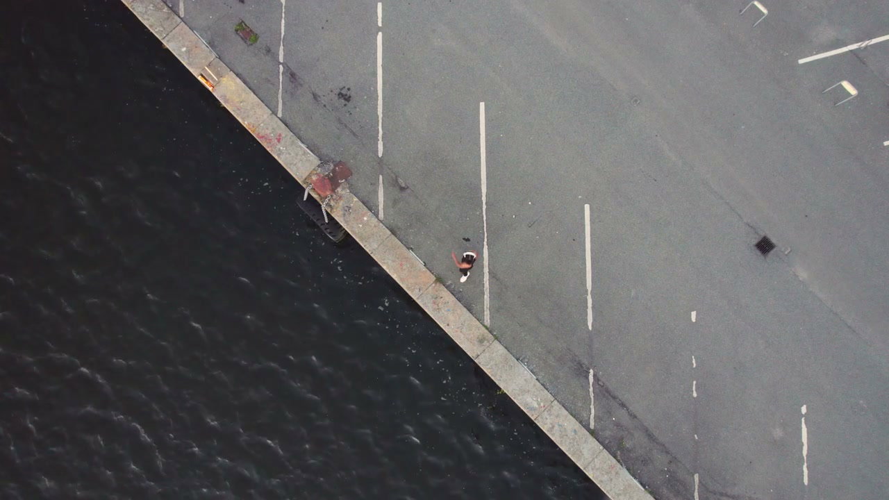 Woman Jogging by Water, Aerial View