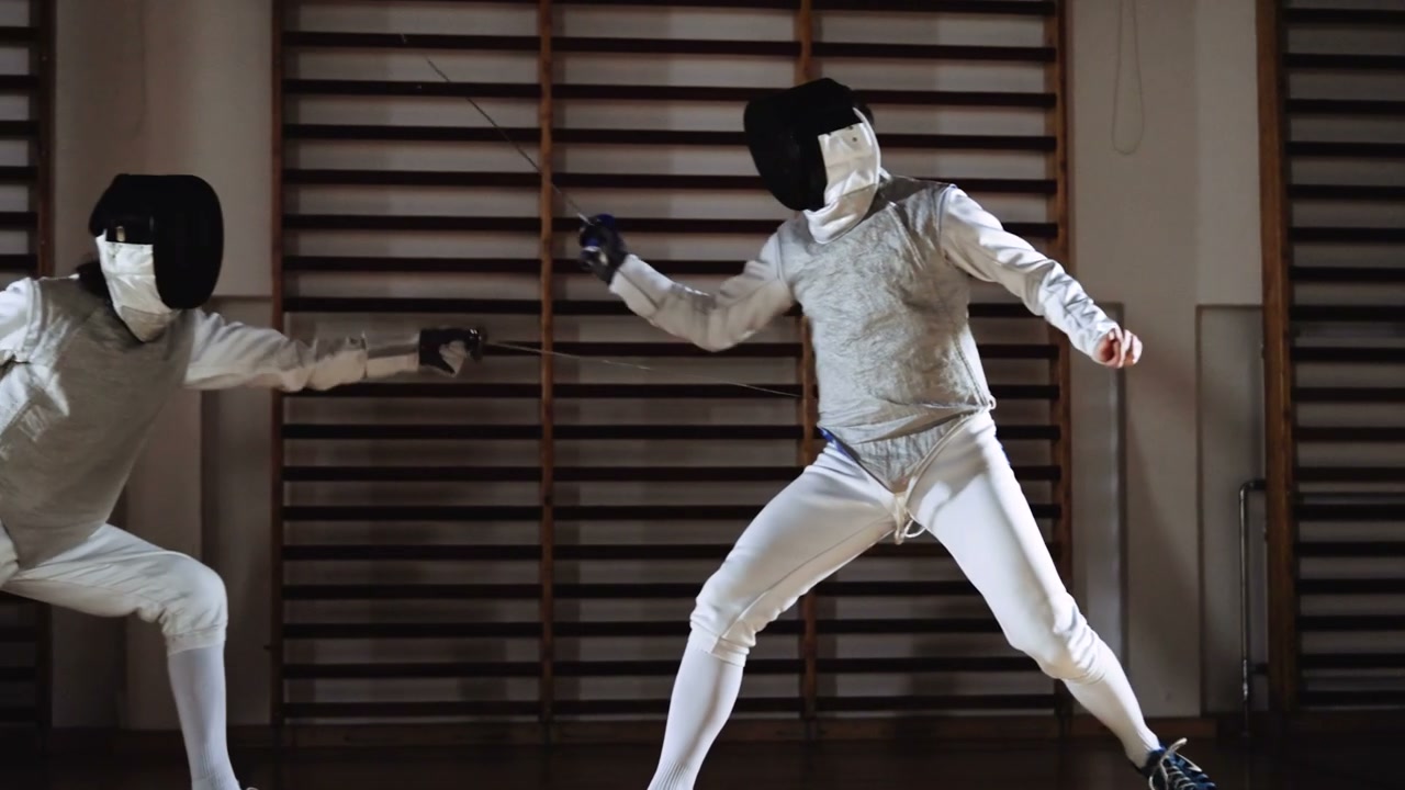 Fencers Duelling in a Gymnasium