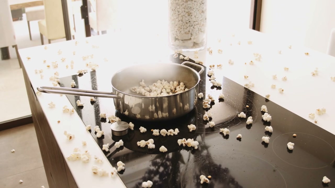 Popcorn Popping and Scattering in a Kitchen • Stock Video on Uppbeat