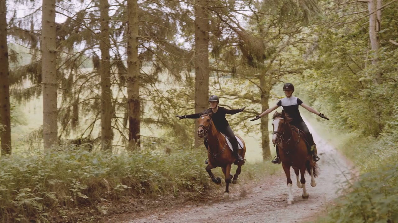 Joyful Riders Galloping Horses with Arms Outstretched