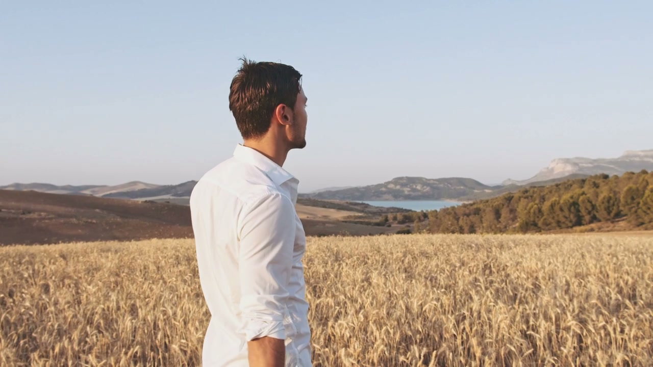 Man Walking Through Golden Wheat Field