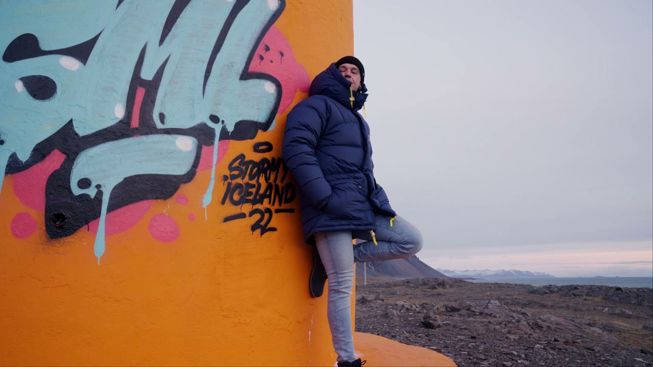 Man Leaning on Hvalnes Lighthouse Wall, Iceland