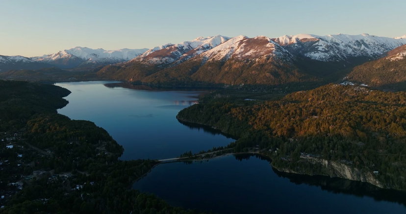 Man Raises Arms by Patagonian Lake at Sunrise • Stock Video on Uppbeat