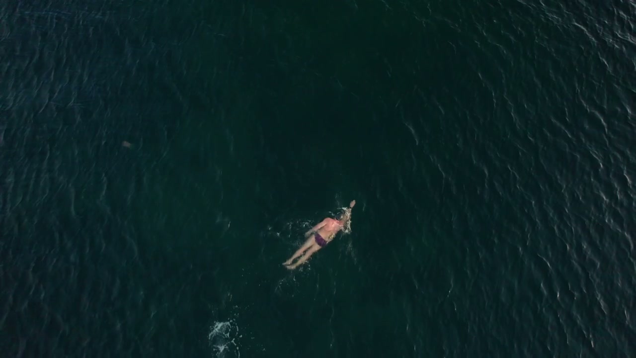 Solo Swimmer in Vast Open Ocean
