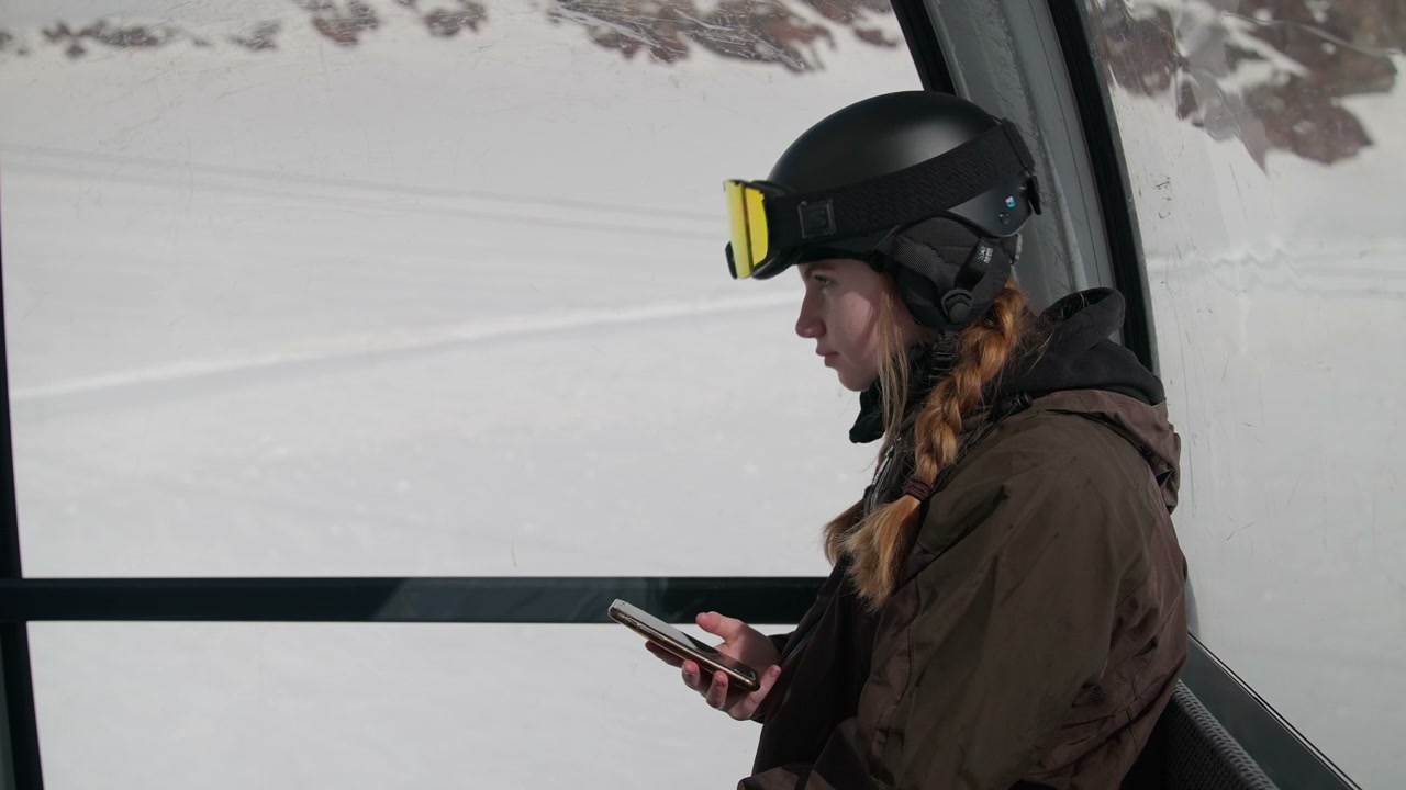 Young Woman on Phone in Ski Gondola