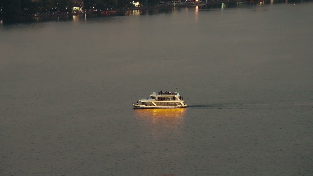 Illuminated Boat Cruising West Lake at Dusk