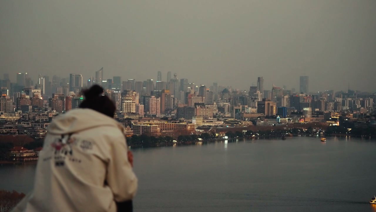 Person Overlooking Hangzhou City Skyline at Dusk